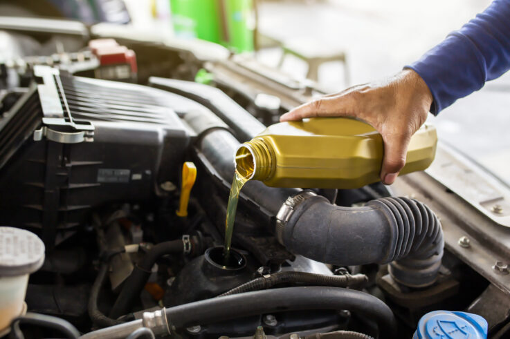 Auto technician performing oil change and brake inspection at a trusted oil change shop Gonzales auto repair service center.